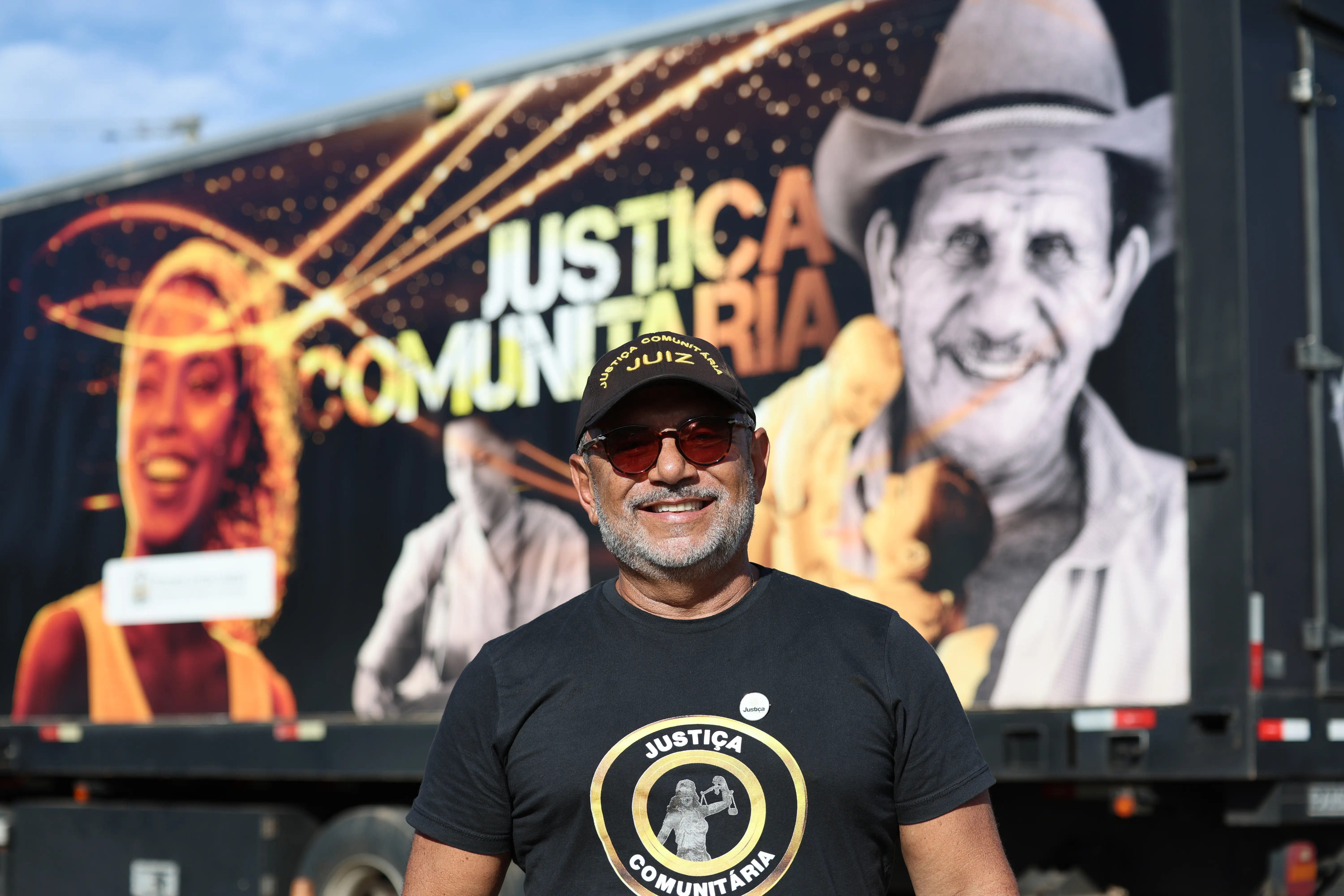 Foto do juiz José Antonio Bezerra Filho sorridente de camiseta e boné pretos escrito 