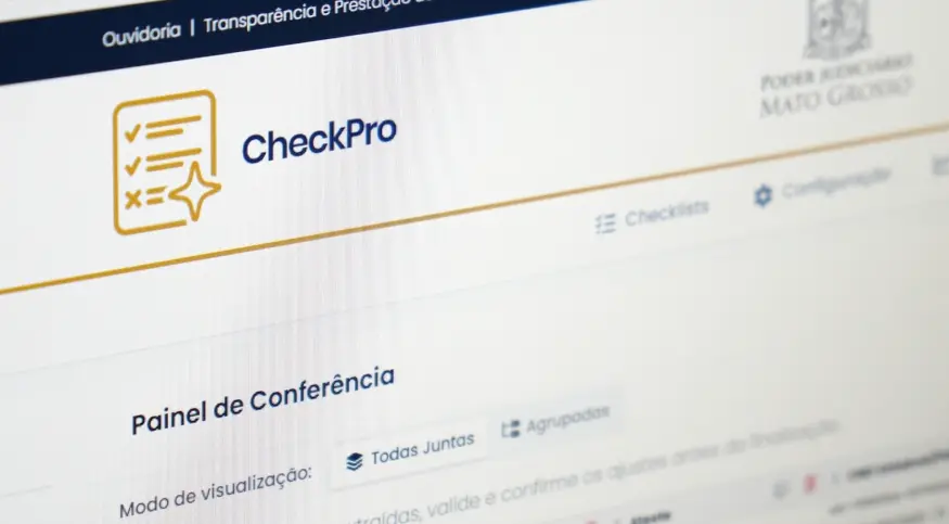 Foto horizontal colorida, em plano fechado, que mostra detalhe da logomarca do sistema CheckPro na tela do computador. A página de internet está aberta no painel de conferência de pagamentos do TJMT.