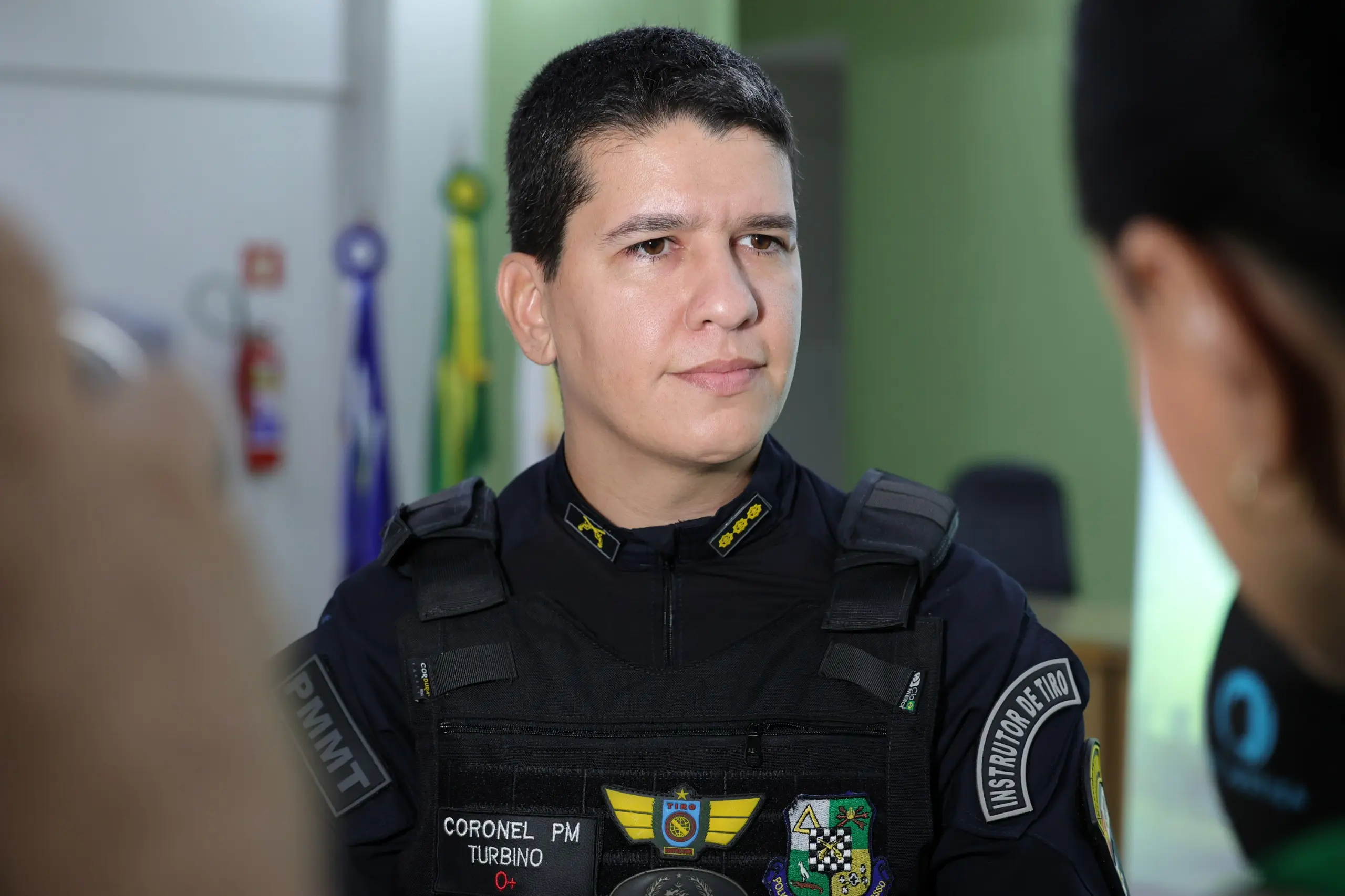Primeiro plano de um homem fardado da Polícia Militar de Mato Grosso (PMMT). No colete há a inscrição